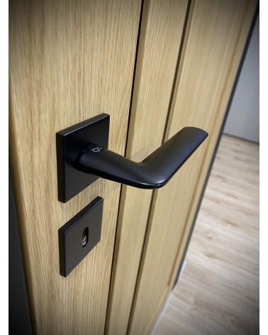 Puxador de porta preto STINGER design vista de cima inclinada montado numa porta