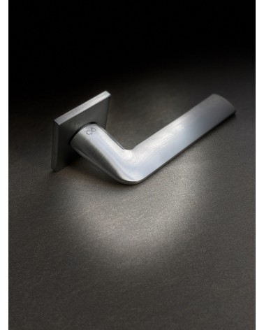 Puxador de porta cromado escovado STINGER puxador design pousado sobre um fundo iluminado