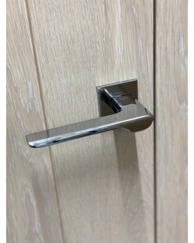Puxador de porta cromado polido LIGNE design vista de cima inclinado montado numa porta