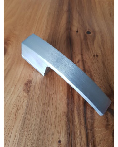 Puxador de porta cromado acetinado Arc design vista de cima inclinado pousado numa placa