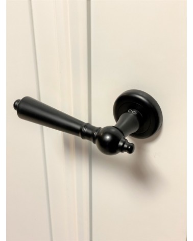 Puxador de porta preto MILLENAIRE puxador design visto de cima inclinado montado numa porta