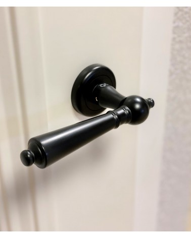 Puxador de porta preto MILLENAIRE puxador design visto de cima ligeiramente inclinado montado numa porta