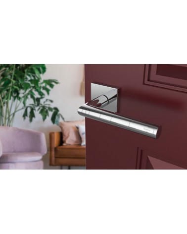 Maçaneta de porta cromada polida ARABIS design montada numa porta ligeiramente aberta
