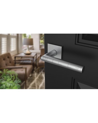 Maçaneta de porta cromada acetinada ARABIS ferragens design montada numa porta ligeiramente aberta