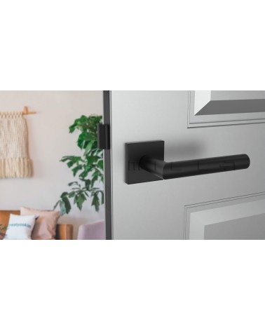 Puxador de porta preto ARABIS puxador design montado numa porta entreaberta