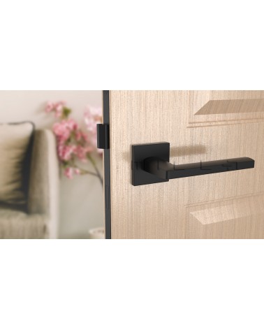 Puxador de porta preto PYROLA ferragens design vista de frente montado numa porta