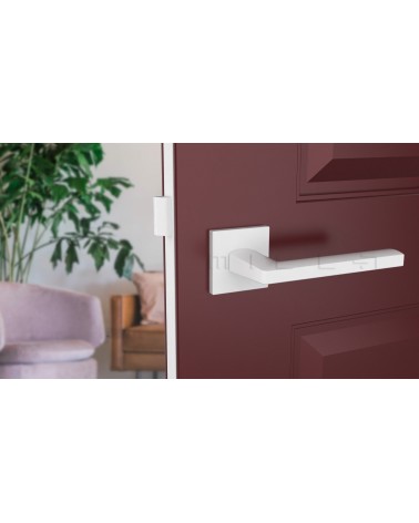 Puxador de porta branco PYROLA ferragens design montado numa porta entreaberta