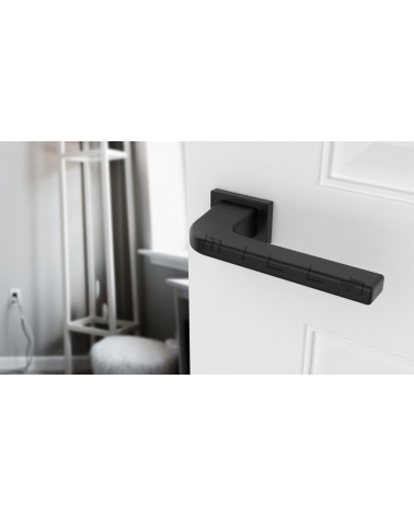 Puxador de porta preto ISMENA ferragens design vista inclinada montado numa porta