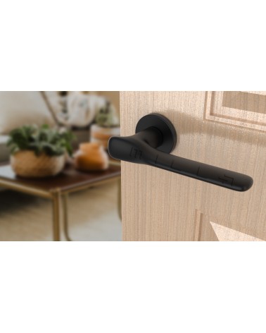 Puxador de porta preto ORCHIDE puxador design visto de lado inclinado montado numa porta