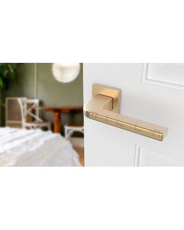 Puxador de porta dourado mate ISMENA puxador design montado numa porta entreaberta