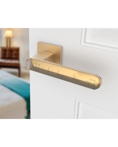 Puxador de porta ouro mate BOHEMA numa porta branca, de lado direito