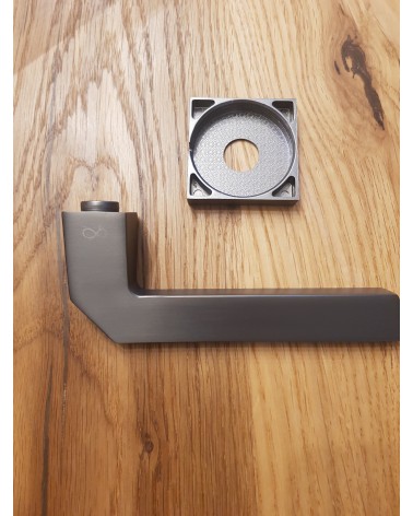Puxador de porta ETNA ferragens design cor 4 pousado sobre uma placa