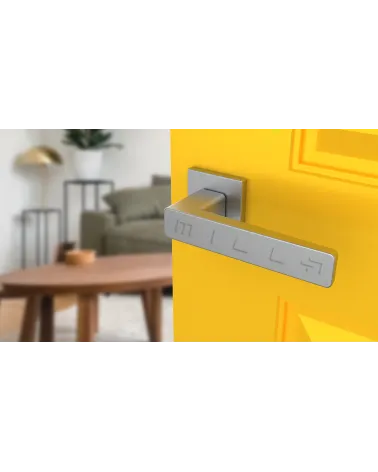 Puxador de porta em placa quadrada ERICA ferragens design cor 2 vista de cima inclinada montado numa porta