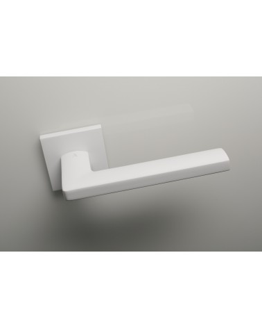 Puxador de porta branco PYROLA ferragens design vista de cima ligeiramente inclinado montado numa porta