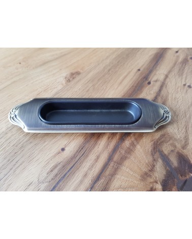 Puxador para porta de correr sóbrio MANDELLI 1028 ferragem design cor 3 pousado sobre uma placa de madeira