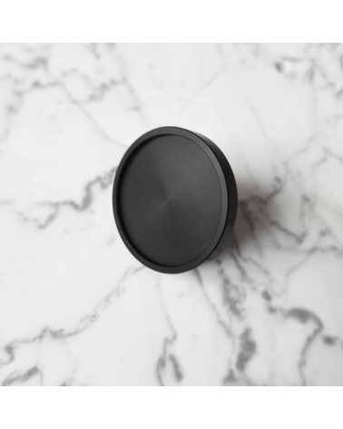 Botão de móvel preto INA BLACK puxador design modelo largo pousado sobre uma superfície marmoreada