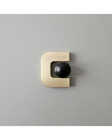 Puxador de móvel ouro polido ISA XS puxador design com uma esfera preta colocada no interior da abertura