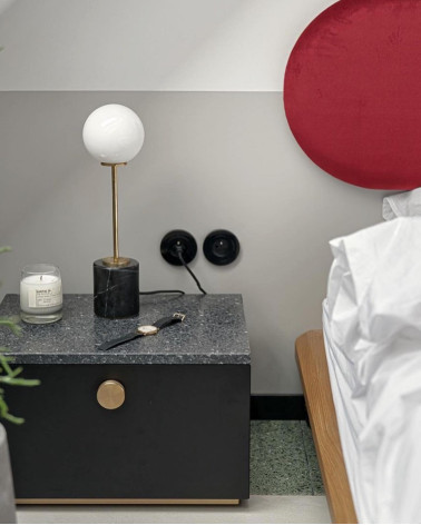 Puxador de móvel dourado mate TOVE design visto de frente instalado numa mesa de cabeceira num quarto