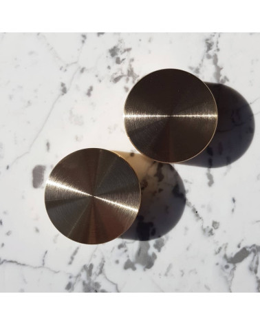 Botão de móvel dourado mate TOVE puxador design colocado sobre uma superfície marmorizada branca