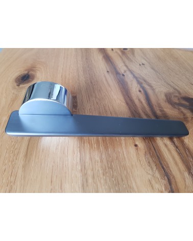 Puxador de porta em zamak JUMELLE design vista lateral pousado sobre uma placa