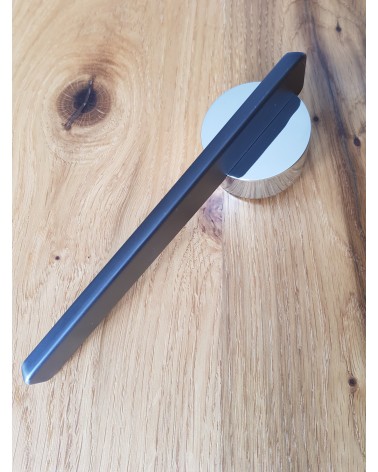 Puxador de porta em zamak JUMELLE design vista de cima inclinada pousado sobre uma placa
