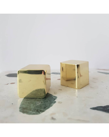 Botão de móvel em latão LANA S puxador design pousados sobre uma superfície em pedra com motivo