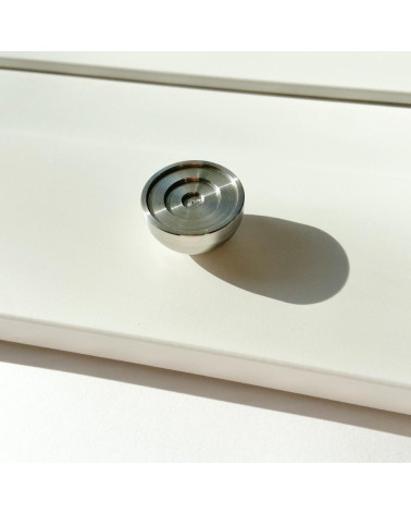 Botão de móvel em aço inoxidável modelo 02 puxador design colocado sobre uma superfície iluminada projetando uma sombra