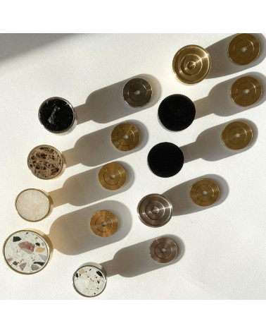 Botão de móvel em latão 02 puxador design visto de cima sobre uma superfície colocado com outros botões