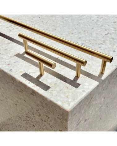 Puxador de móvel em latão T-Bar design de puxador vista lateral sobre uma superfície em pedra com puxadores alinhados em segundo