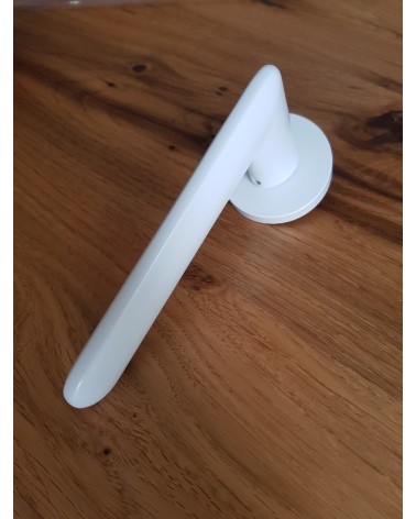 Puxador de porta branco Spark design visto de cima inclinado pousado sobre uma placa