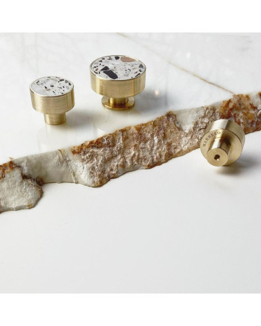 Puxador de móvel em latão e Terrazzo design de tamanhos variados sobre uma superfície de mármore