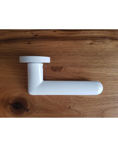 Puxador de porta branco Spark design visto de lado pousado sobre uma placa