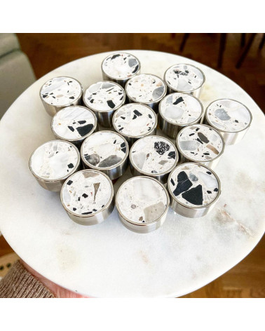Puxador de móvel em latão e Terrazzo design dispostos em pilha sobre uma superfície de mármore