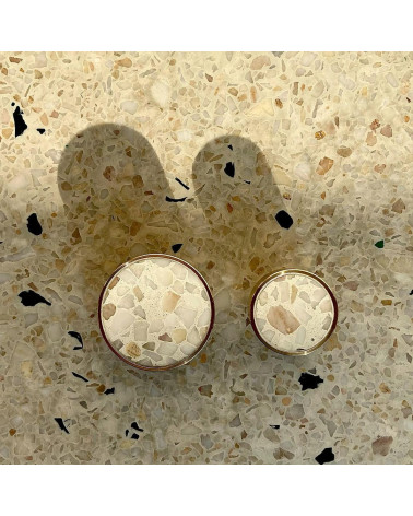 Puxador de móvel em latão e Terrazzo design visto de cima alinhados sobre uma superfície em terrazzo