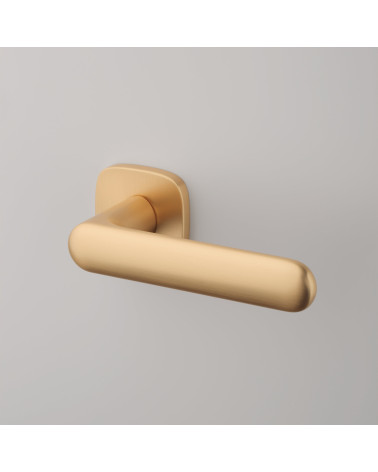 Puxador de porta dourado mate OLEA puxador design vista de cima inclinada fixado num fundo