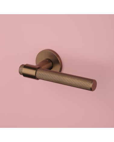 Puxador de porta castanho claro GOYA puxador design vista de cima inclinada sobre fundo rosa