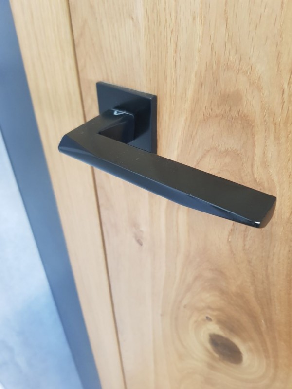 puxador preto design numa porta de madeira