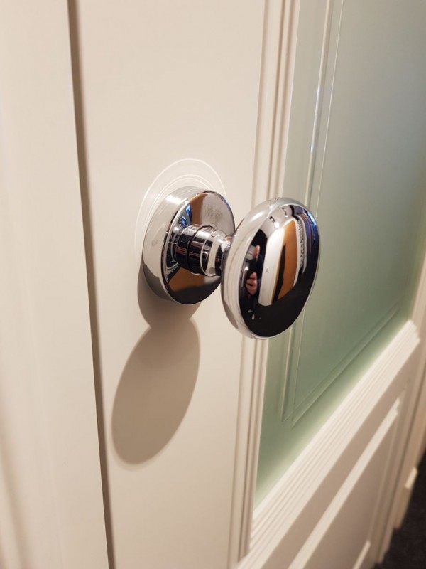 botão de porta numa porta branca de vidro